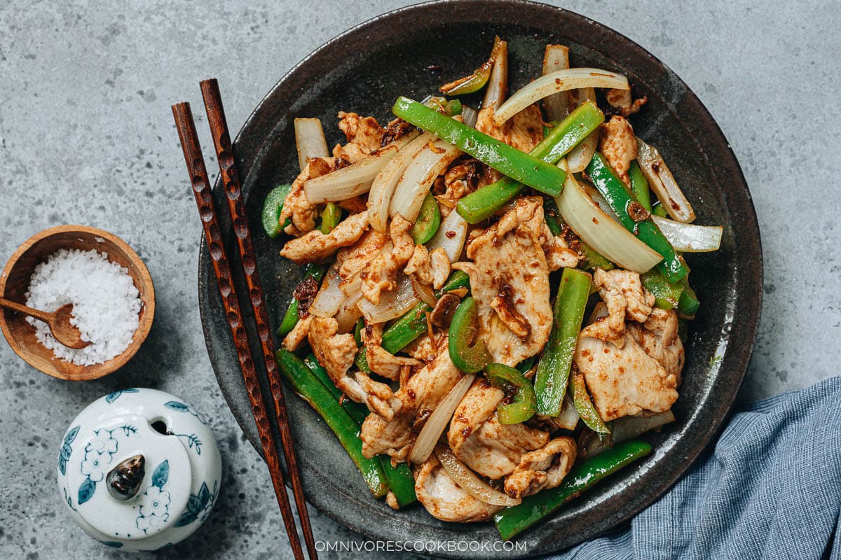 Shacha chicken stir fry with onion and bell pepper glazed in shacha sauce on a plate
