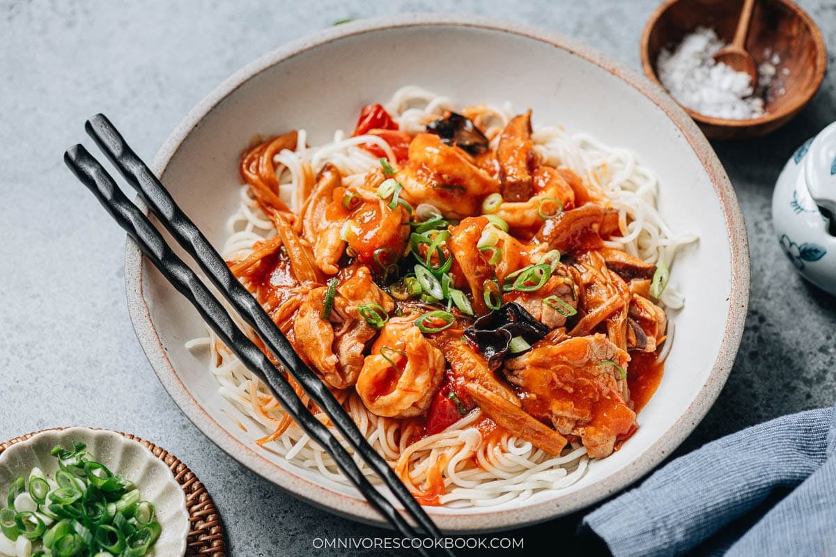 hot da lu mian gravy ladled over wide wheat noodles on a plate