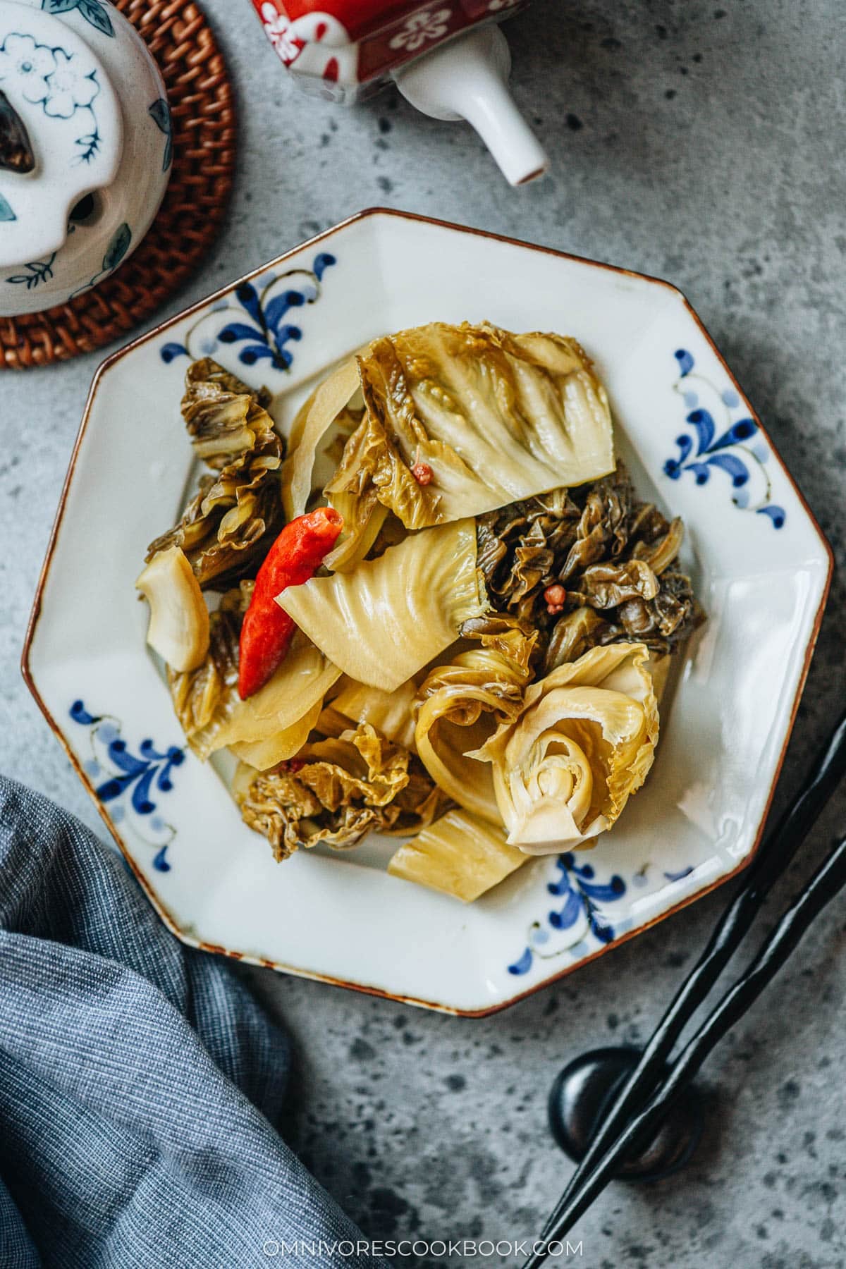 Sichuan pickled mustard greens with ginger, dried chilies, and Sichuan peppercorns on a plate